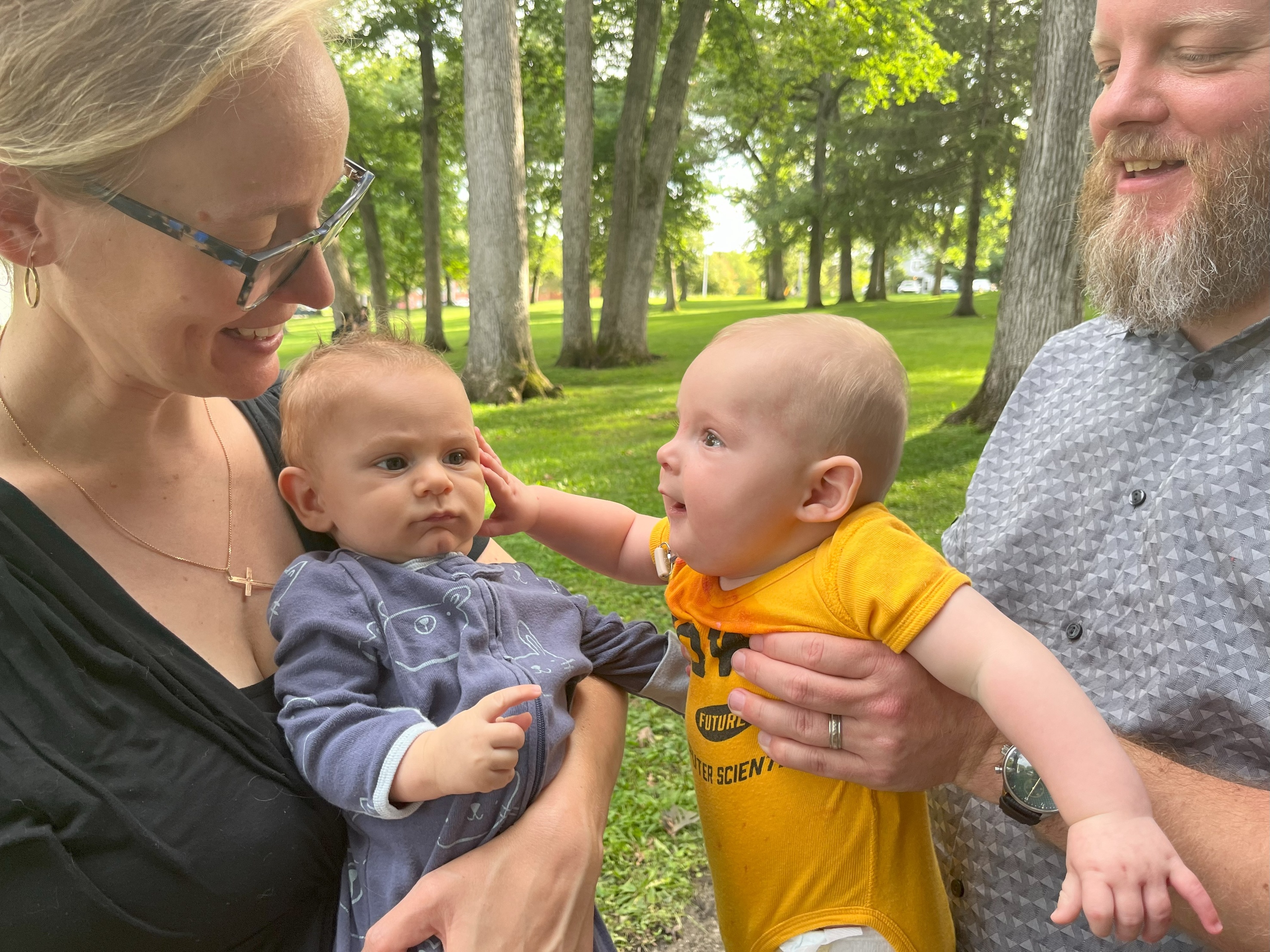 Picture of UIowaCS Dept Administrator Alli Rockwell and faculty member Garrett Morris, with their respective babies. Morris baby is seen wearing an "IOWA Future Computer Scientist" onesie.