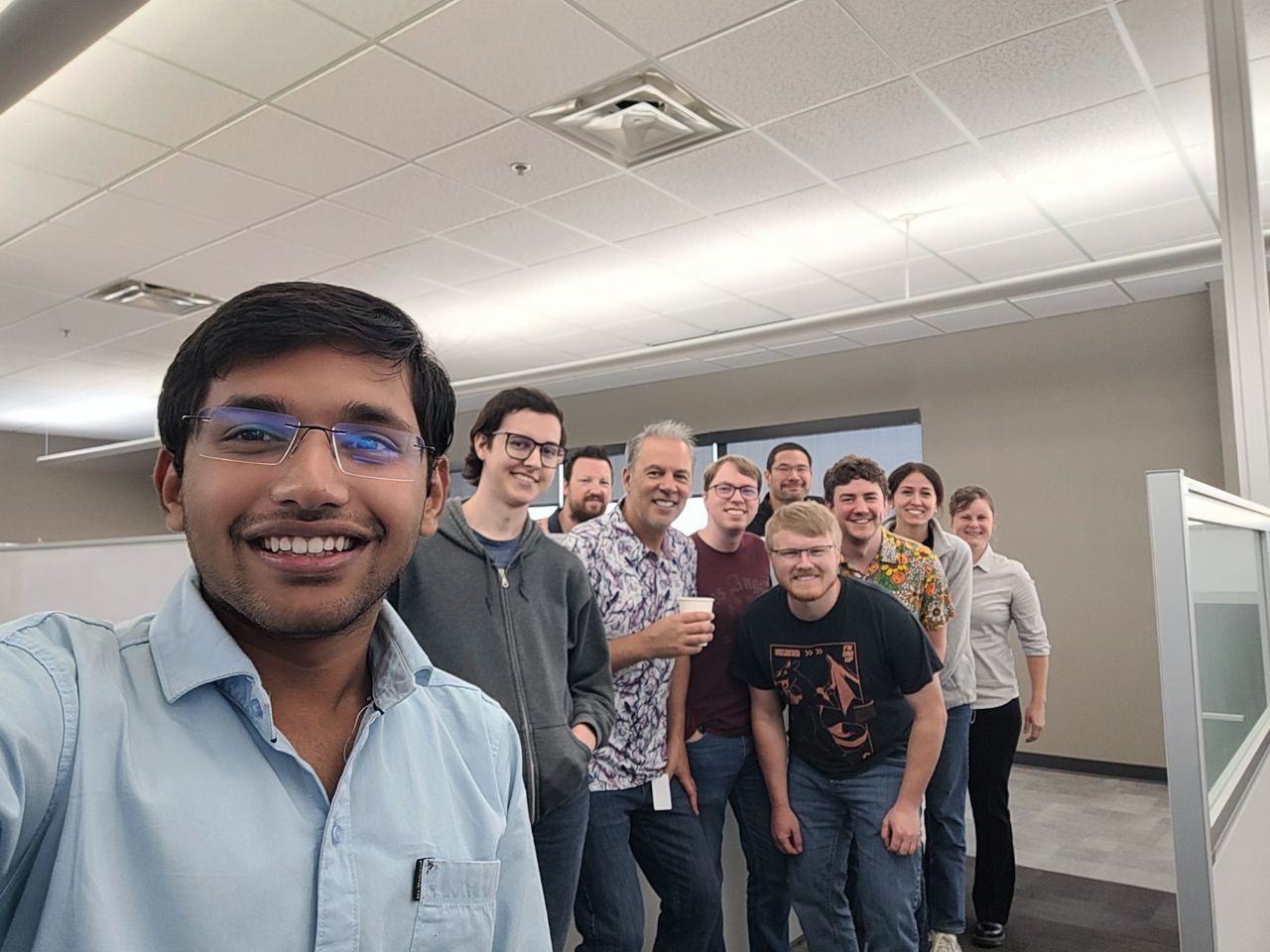 Nahar takes a selfie with a group of 9 other people on his team.