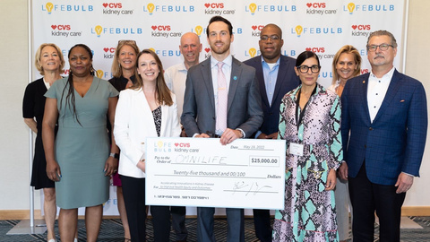 OmniLife, represented by Co-Founder and CEO Dalton Shaull receiving an oversized $25,000 check, surrounded by other unidentified persons.