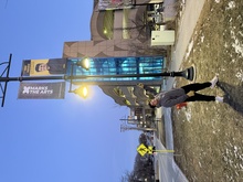 PhD student Vinay Pursnani points to an outdoor banner haning on a lightpost in Iowa City that honors him as part of the University of Iowa's Dare to Discover program