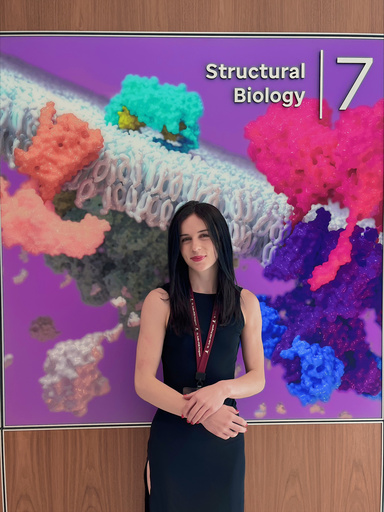 Liz Elias standing in front of a sign that says "Structural Biology"