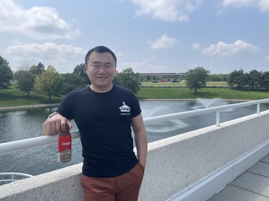 Vincent Cai standing outside of Casey's Corporate Headquarters in Ankeny, Iowa wearing a Casey's shirt and holding a Casey's iced coffee.