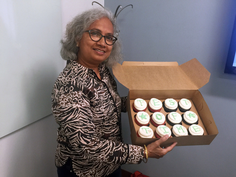 Srinivasan holding congratulatory cupcakes, courtesy of her research group.