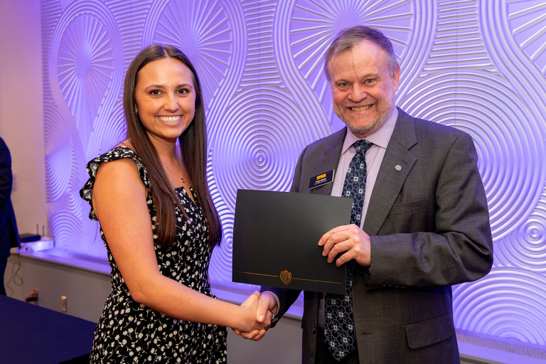 Rachel Fitzjerrells receiving award certificate from UI VPR Marty Scholtz