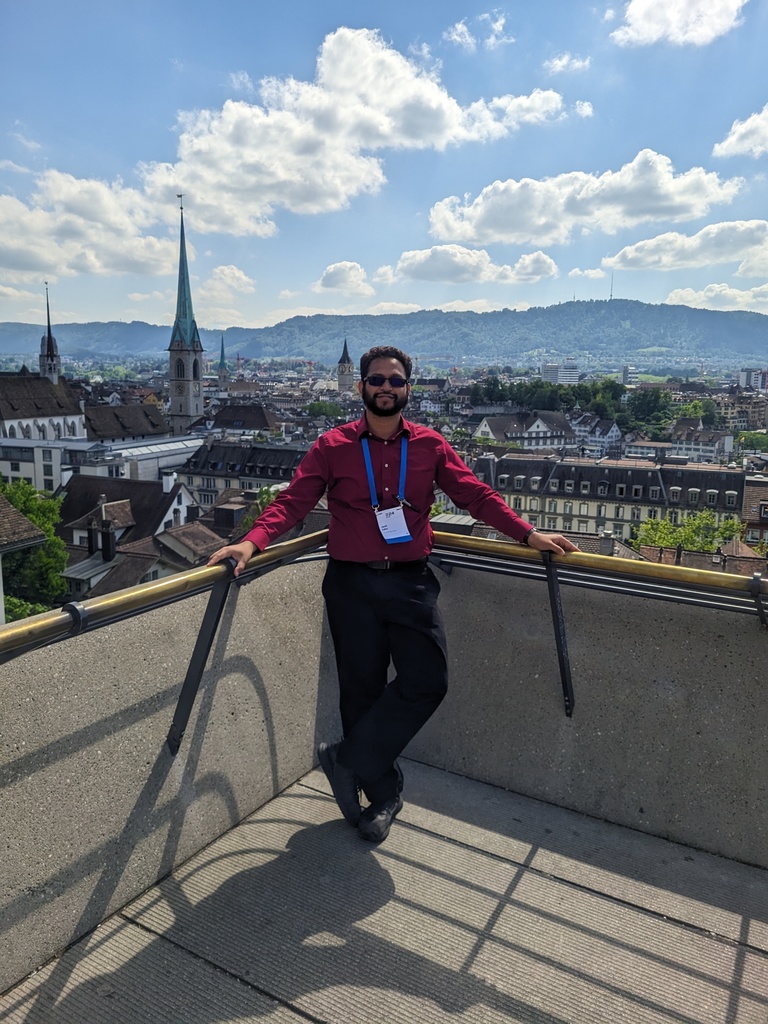 Jamil standing on the rooftop of the PASC24 venue, with the beautiful scenery of Zurich, Switzerland, behind him. 