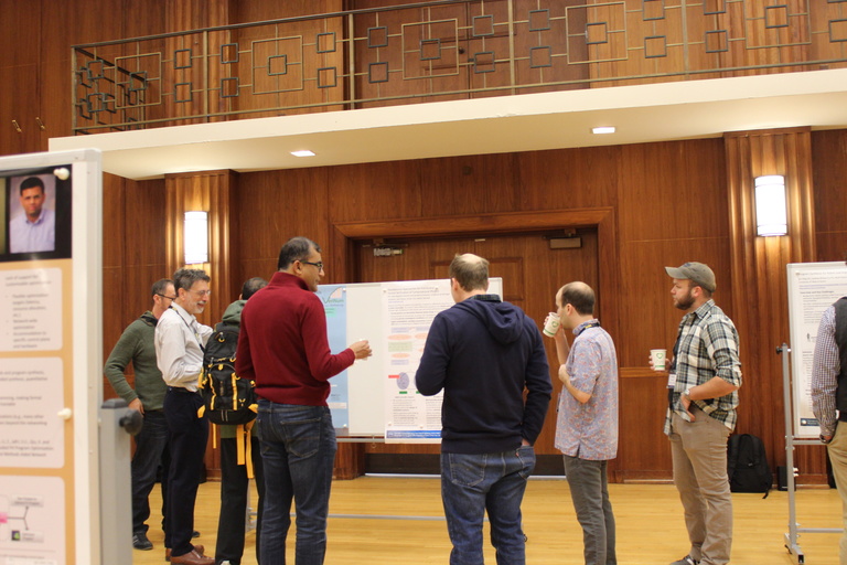 Meeting attendees gather around a whiteboard to read a poster during Wednesday's poster session.