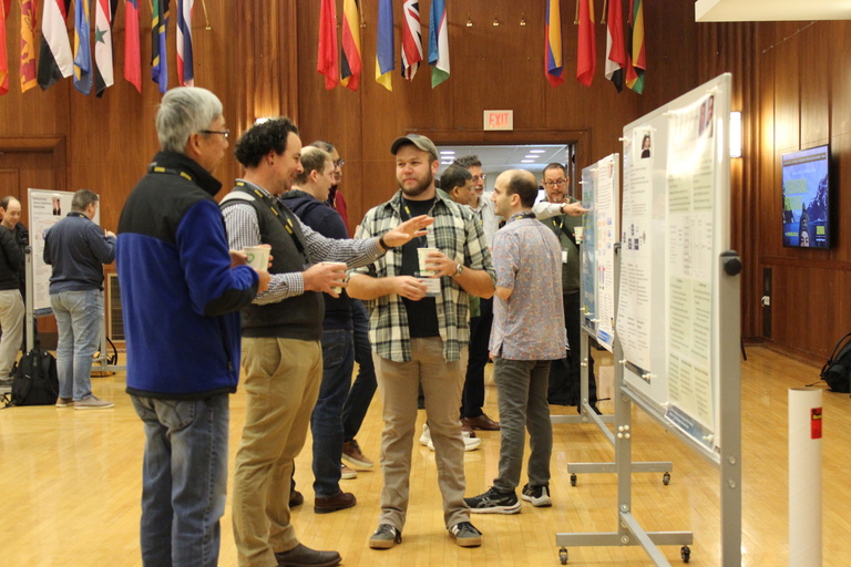 Participants gather around a white board to read a poster