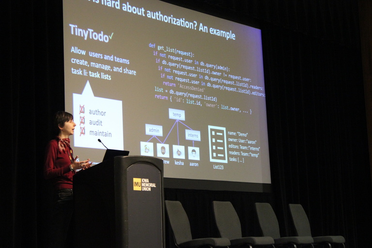 Emina Torlak standing at a podium in front of a screen presenting her research