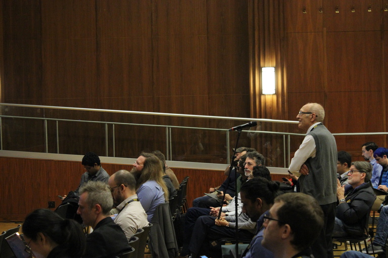 An attendee asks a question into a microphone during a Q&A session 