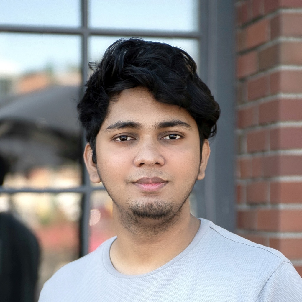 Nikhil Singh portrait in front of brick wall and window - submitted