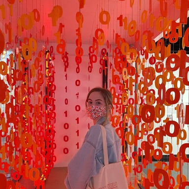Sarah Altemeier pictured with bits (0s and 1s) hanging from ceiling