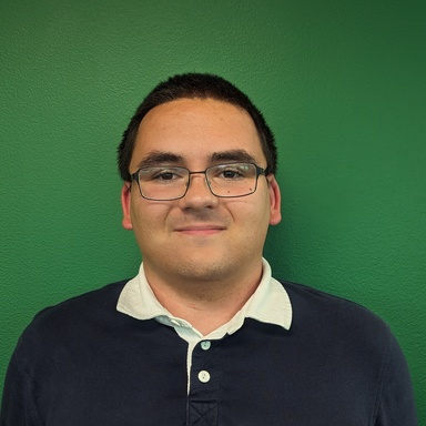 Nathan Jankowski standing in front of a solid green background