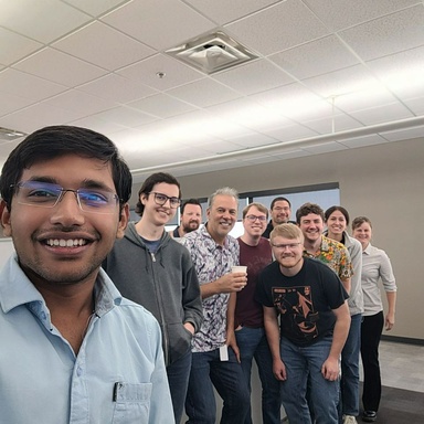 Nahar takes a selfie with a group of 9 other people on his team.