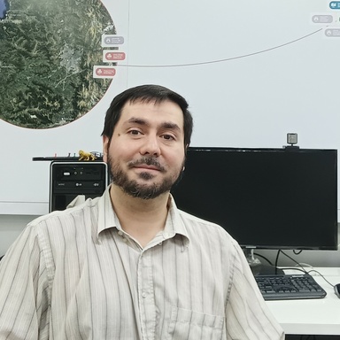 Mauricio Monsalve sitting in front of a computer with a map behind him.