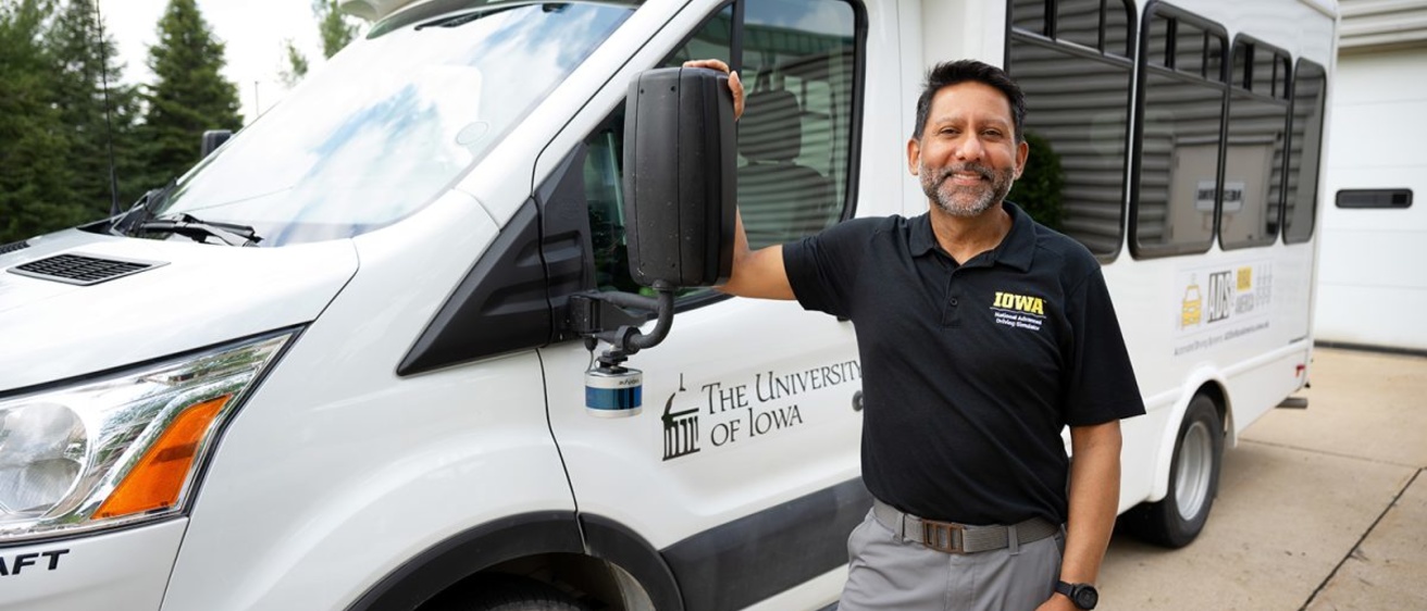 Justin Torner – Staff Photograph; Ahmed posing next to a project vehicle