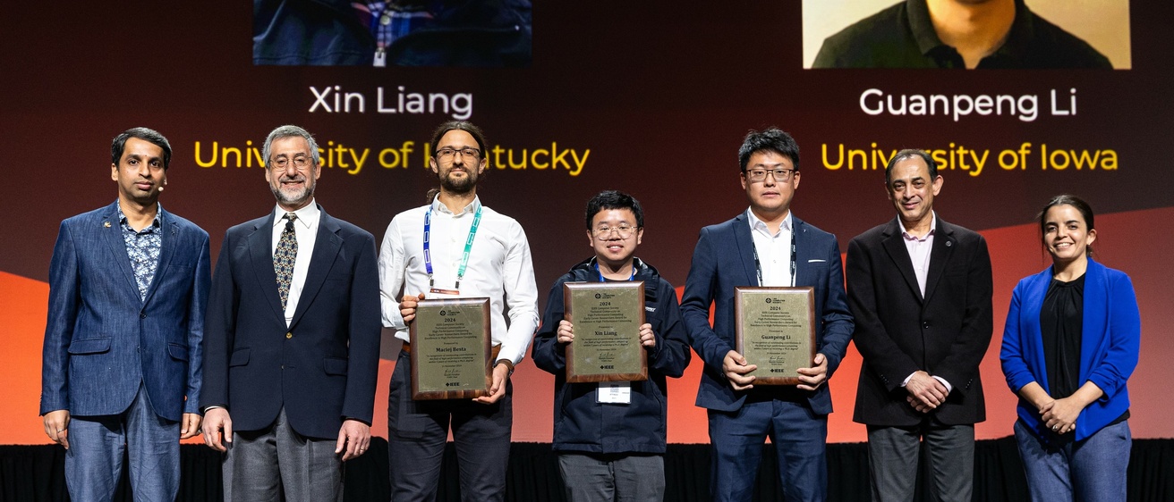 Li stands onstage at SC24 holding his Award for Excellence for Early Career Researchers in High Performance Computing