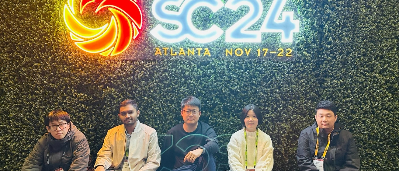 The UIowaCS group for SC'24 poses in front of a neon sign reading "SC'24". From left to right: Yafan Huang, Md Hasanur Rahman, Guanpeng Li, Shihui Song, and Bohan Zhang.