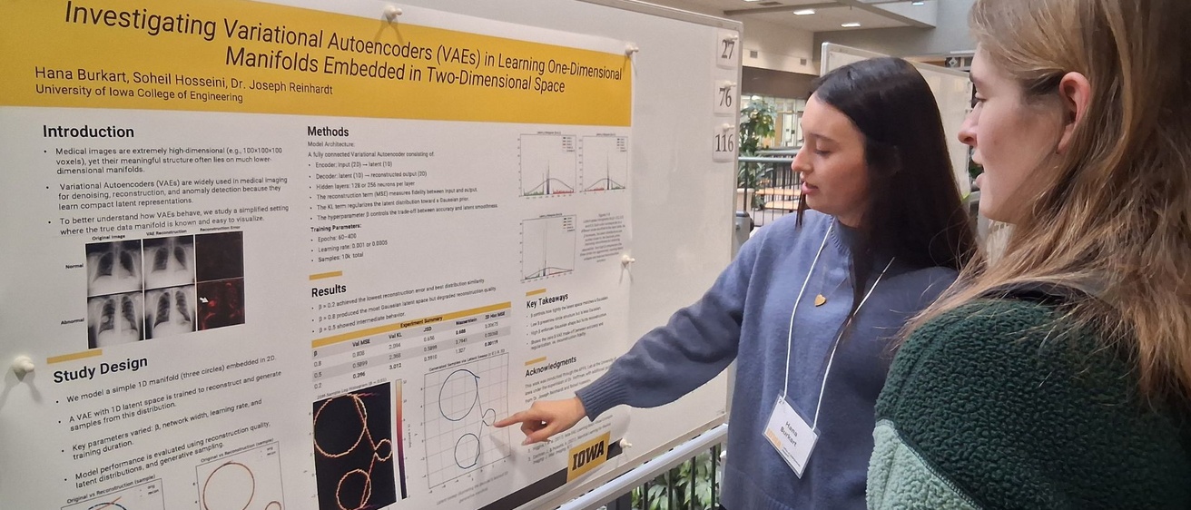 CD student shares her research poster with another student