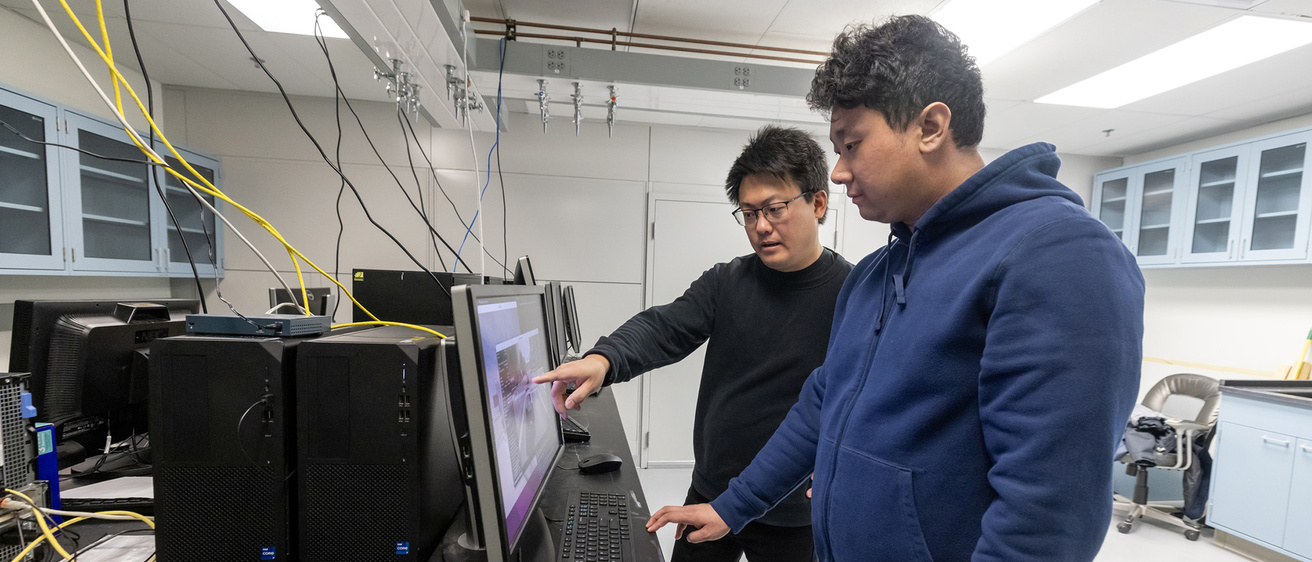 Instructor and student working together in a computer lab