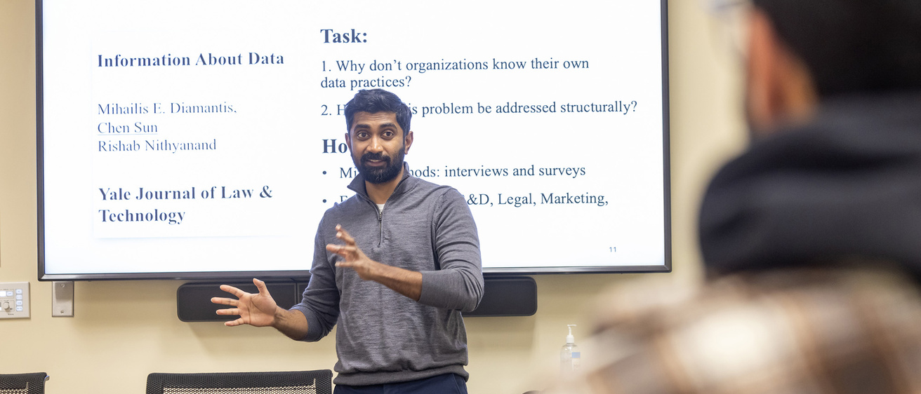 A view of a teacher explaining data science principles written on a whiteboard behind him.