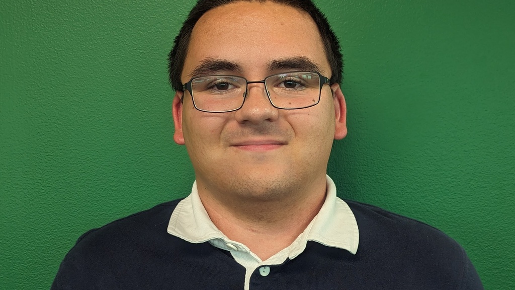 Nathan Jankowski standing in front of a solid green background