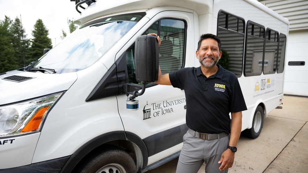 Justin Torner – Staff Photograph; Ahmed posing next to a project vehicle
