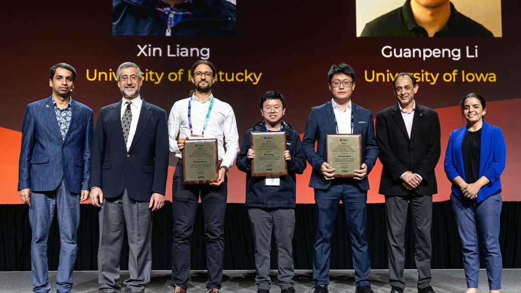 Li stands onstage at SC24 holding his Award for Excellence for Early Career Researchers in High Performance Computing