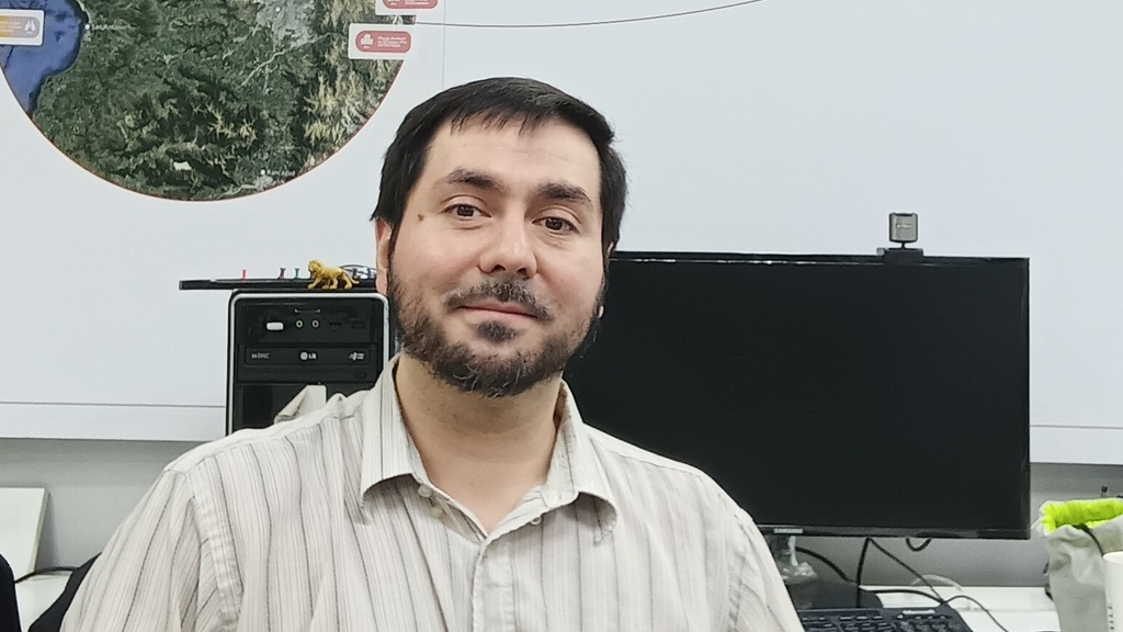 Mauricio Monsalve sitting in front of a computer with a map behind him.